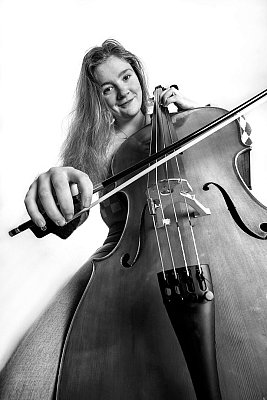 Studio portrait of a girl playing a cello in black and white.